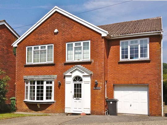 detached red brick house with white upvc windows