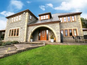 detached grey brick house with oak effect upvc windows