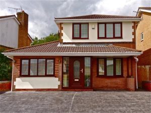 cream and red brick detached house with rosewood effect windows