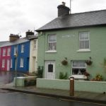 A house painted green with white windows