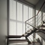 Tall windows in the stair case with shutters fitted