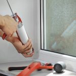 A window repair man with a sealant gun
