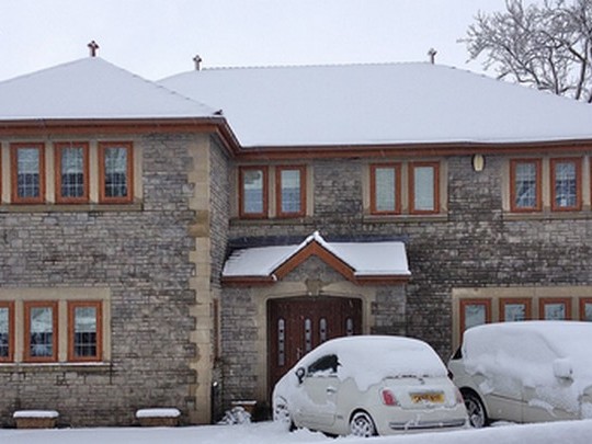 snow covered house with golden oak effect double glazed windows