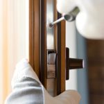 A repair man fixing a broken lock and door handle