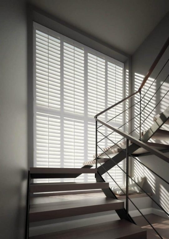 Tall windows in the stair case with shutters fitted