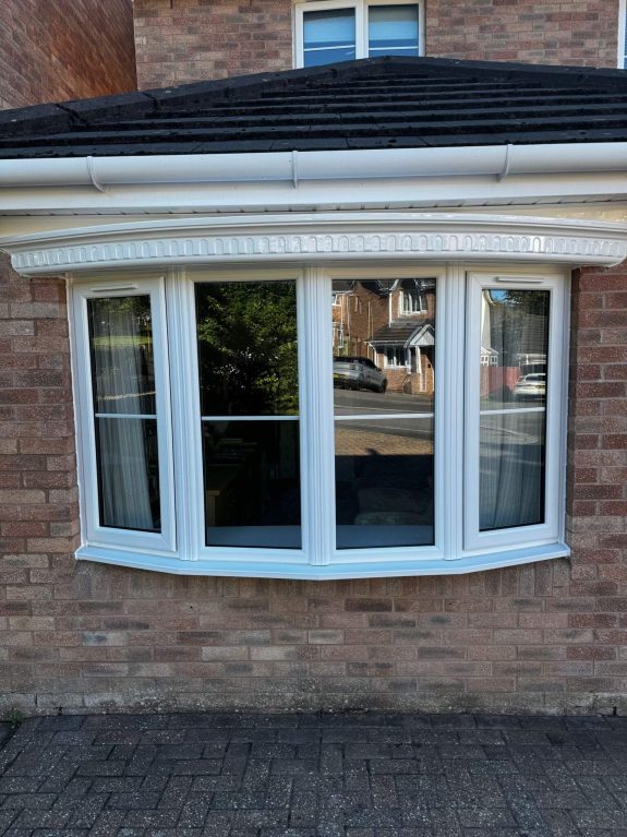 Before and after of a bow bay window conversion with white rehau upvc windows and a pvc canopy